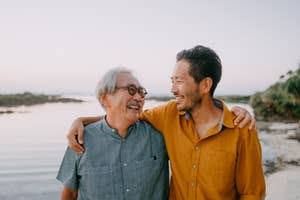 Two men, likely family, sharing a joyful moment with a natural backdrop, reflecting a sense of well-being and connection