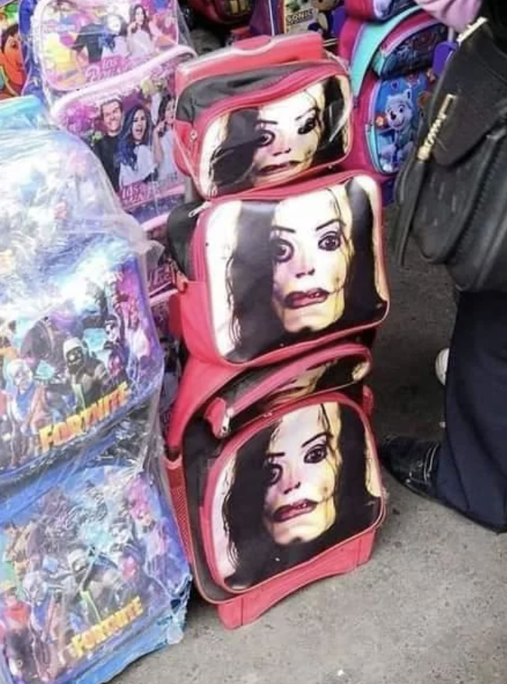 Stacked children&#x27;s backpacks with distorted print of a female character&#x27;s face from media