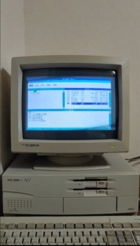 古いスタイルのパソコンとモニターが机の上に置かれています。