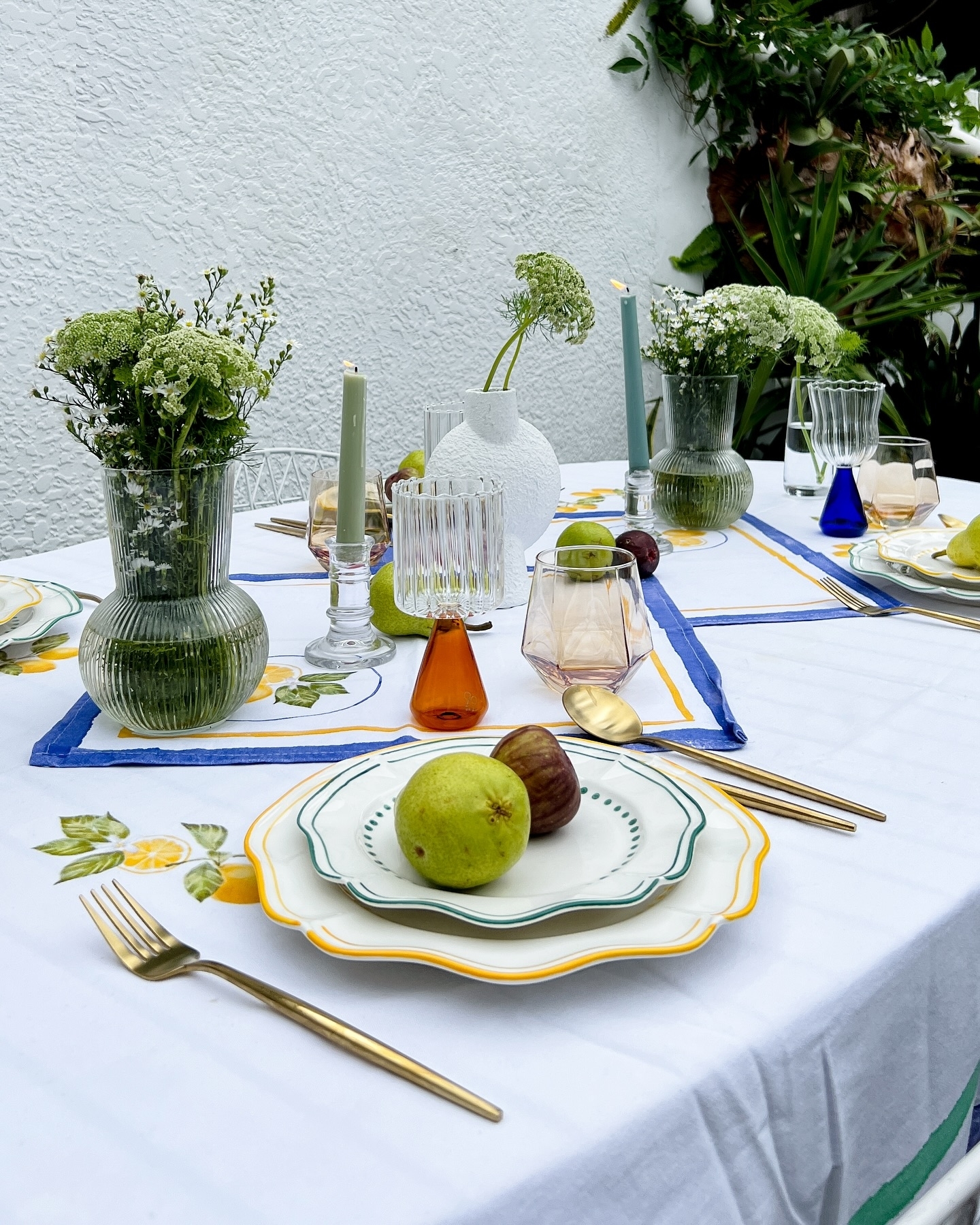 Elegantly set table with tableware, glassware, and a centerpiece for sophisticated outdoor dining
