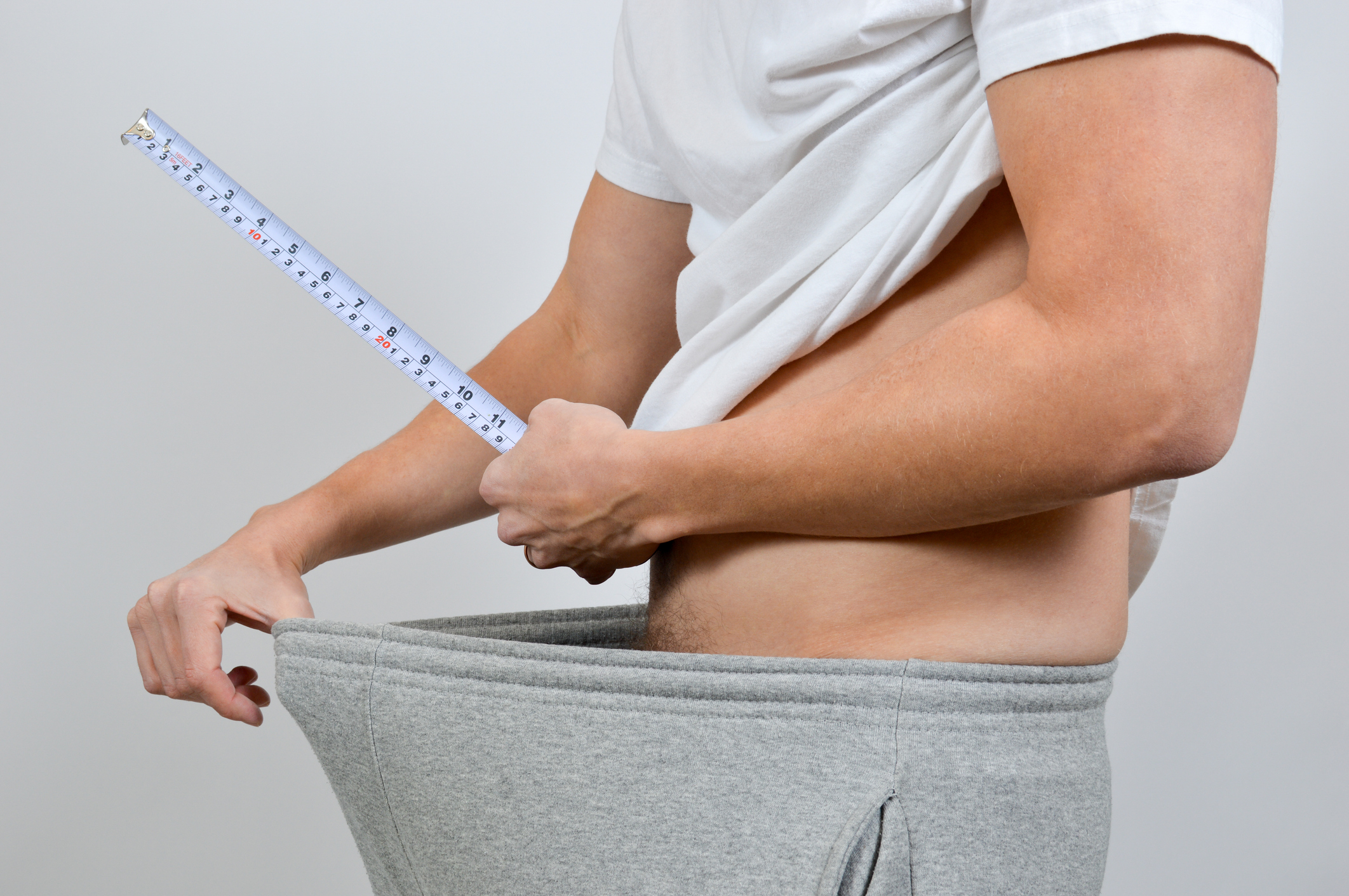 Person measuring their waist with a tape measure