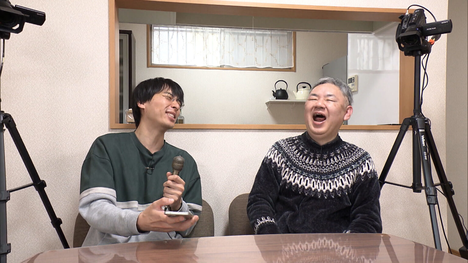 二人の男性がインタビューを楽しみながら笑っている様子。