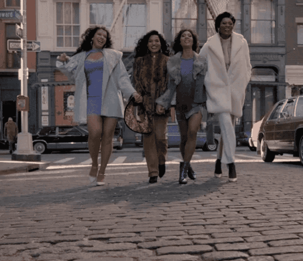 gif of Four women walking side by side, smiling, dressed in trendy streetwear
