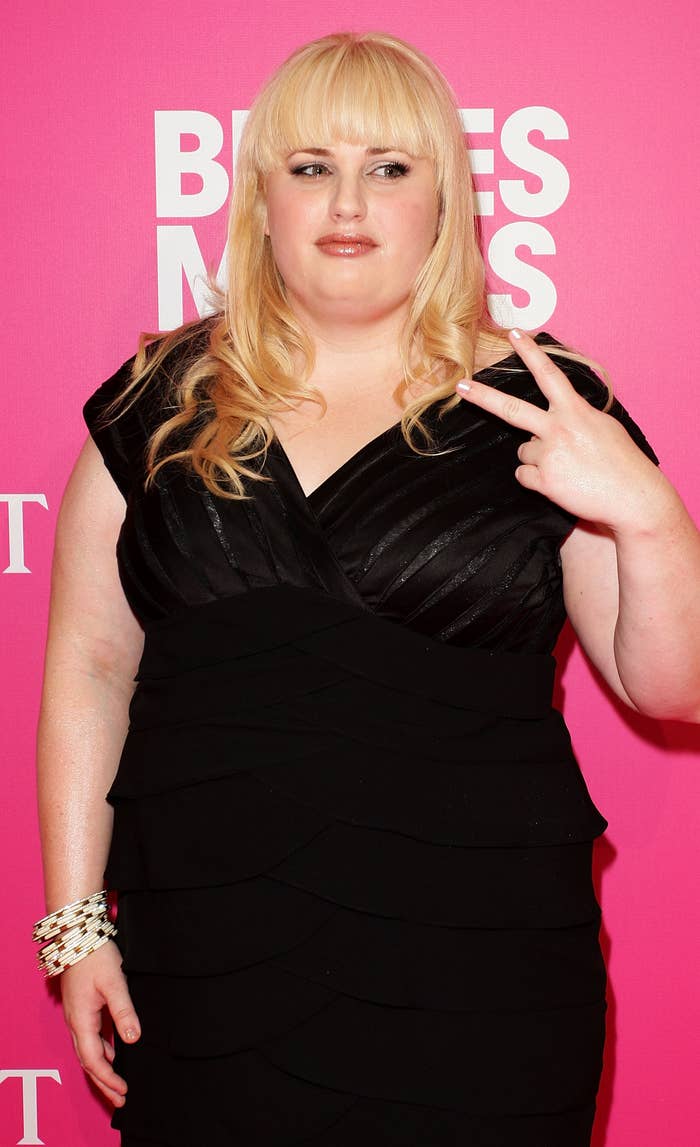 Rebel Wilson in a dress giving the peace sign, at a Bridesmaids event