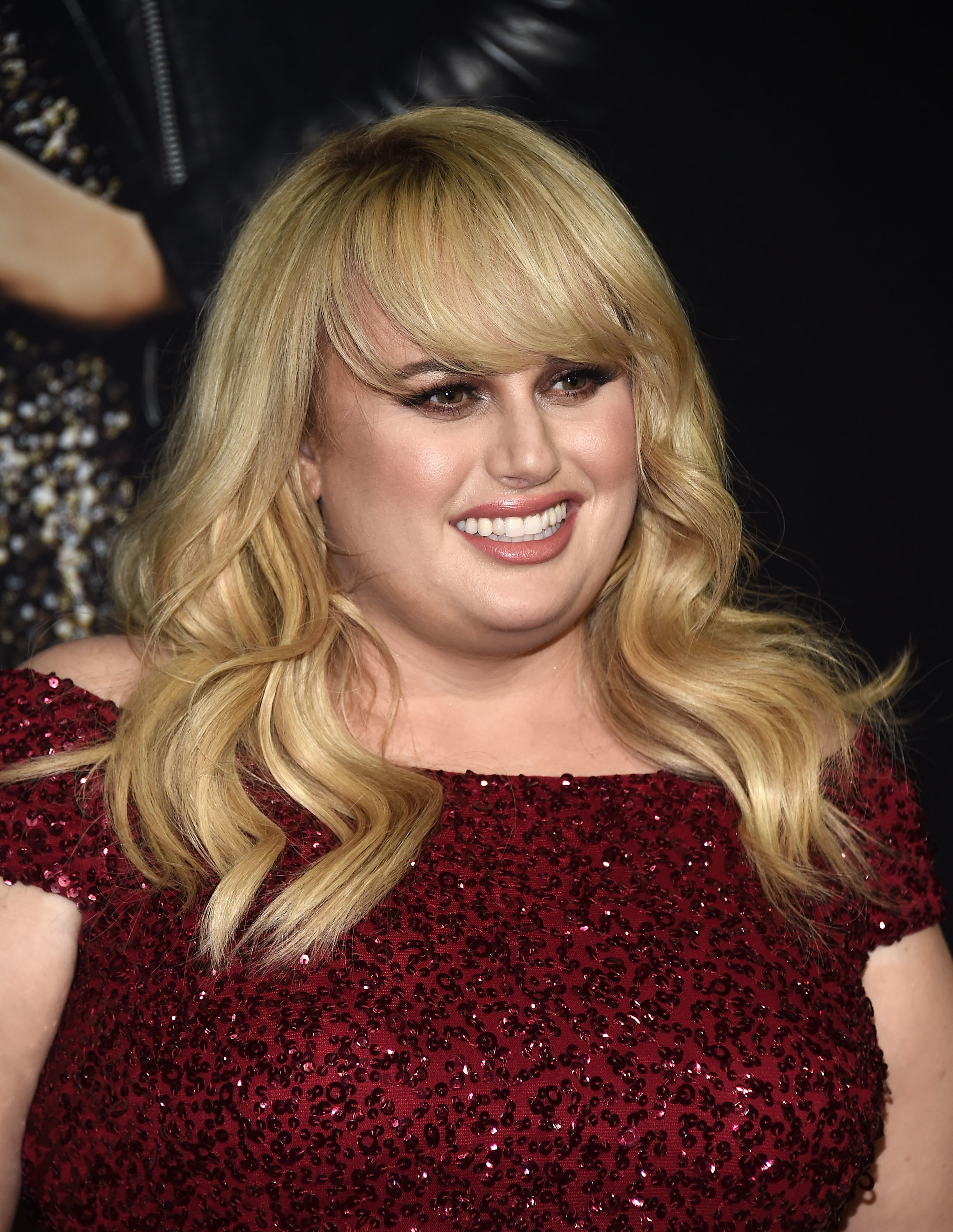 Rebel Wilson in a sequined dress smiling at an event