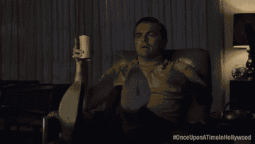 Leonardo DiCaprio as Rick Dalton in &#x27;Once Upon a Time in Hollywood,&#x27; lounging with a drink and TV remote
