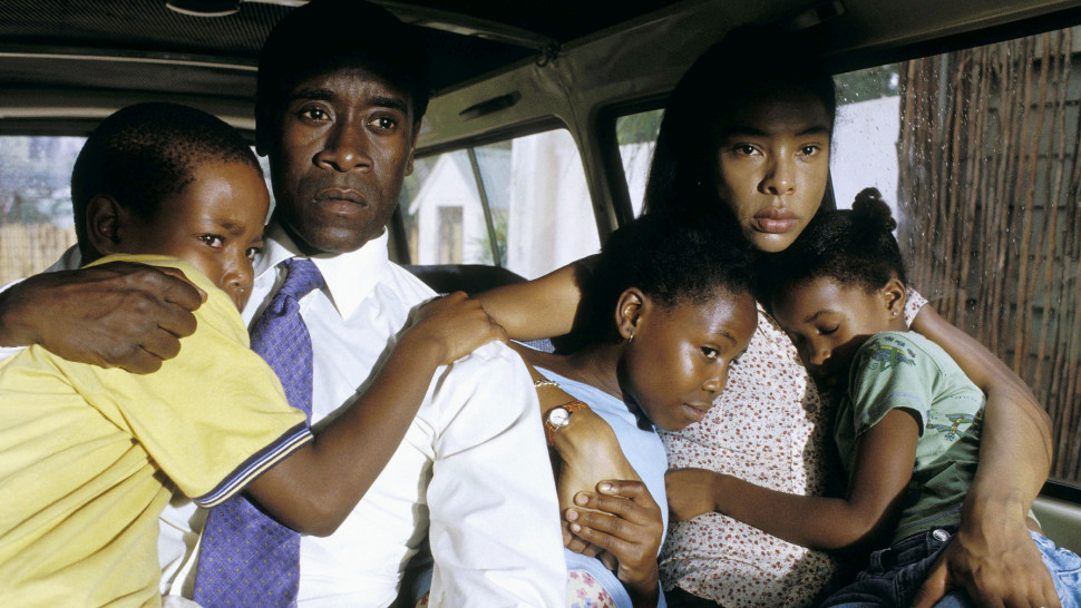 A family of four looking concerned, seated closely together inside a vehicle