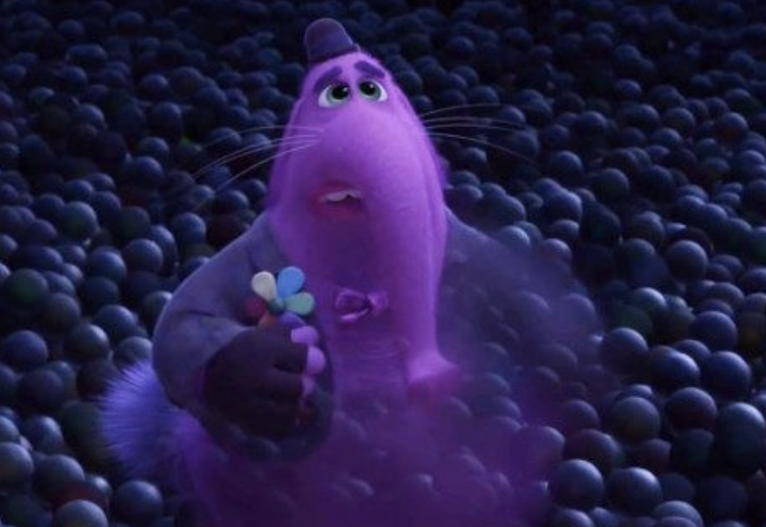 Bing Bong from Inside Out stands among memory orbs holding a pink candy flower