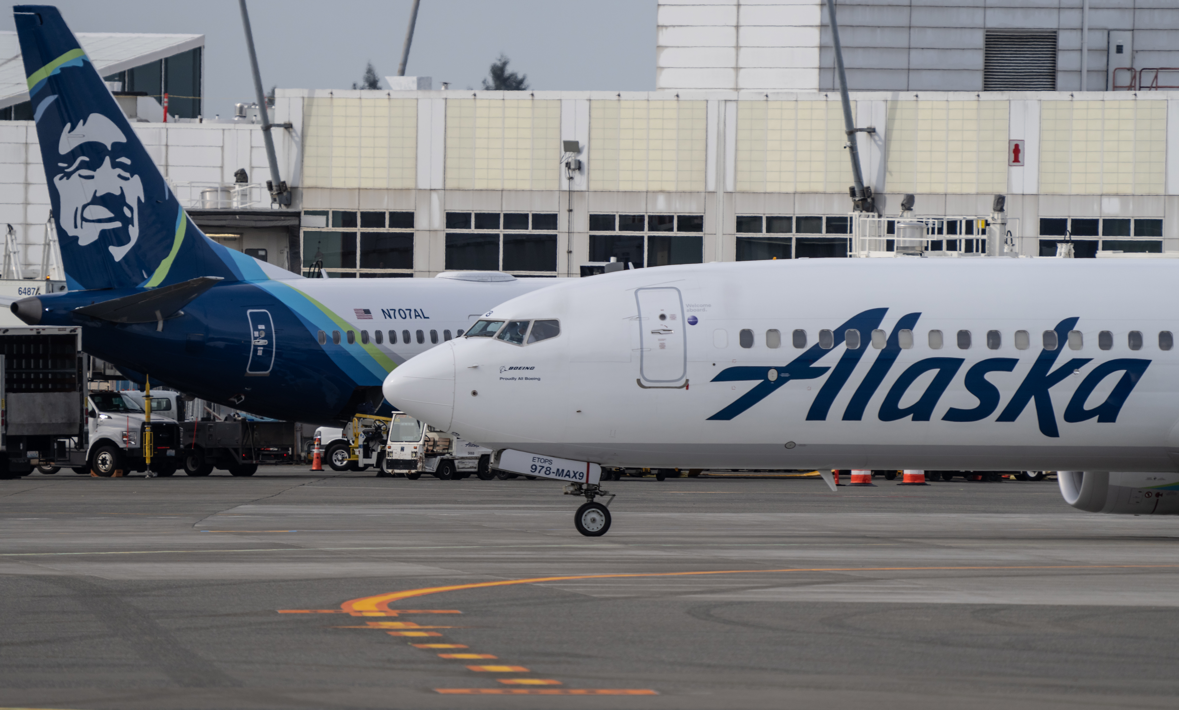 Two Alaska Airlines aircraft at an airport, with distinctive company branding on the tail and fuselage