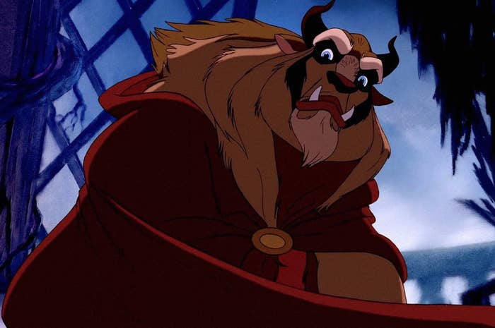 Animated character Beast from Beauty and the Beast wearing a red cape looking surprised