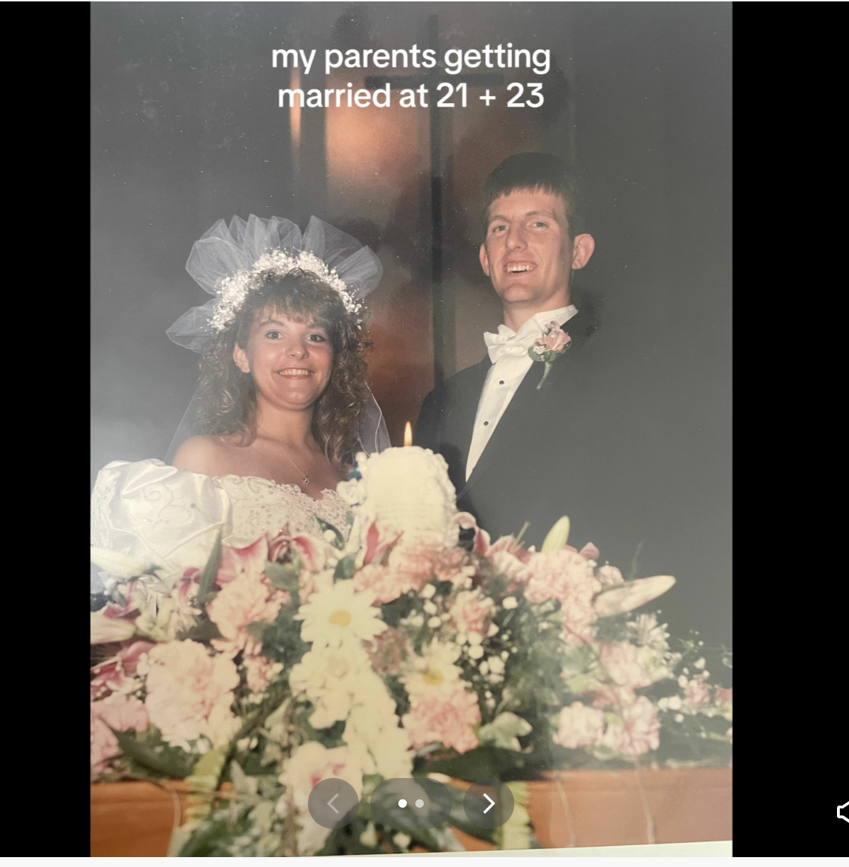 Wedding photo of a couple with the bride in a white gown with a veil and the groom in a black suit with a bow tie