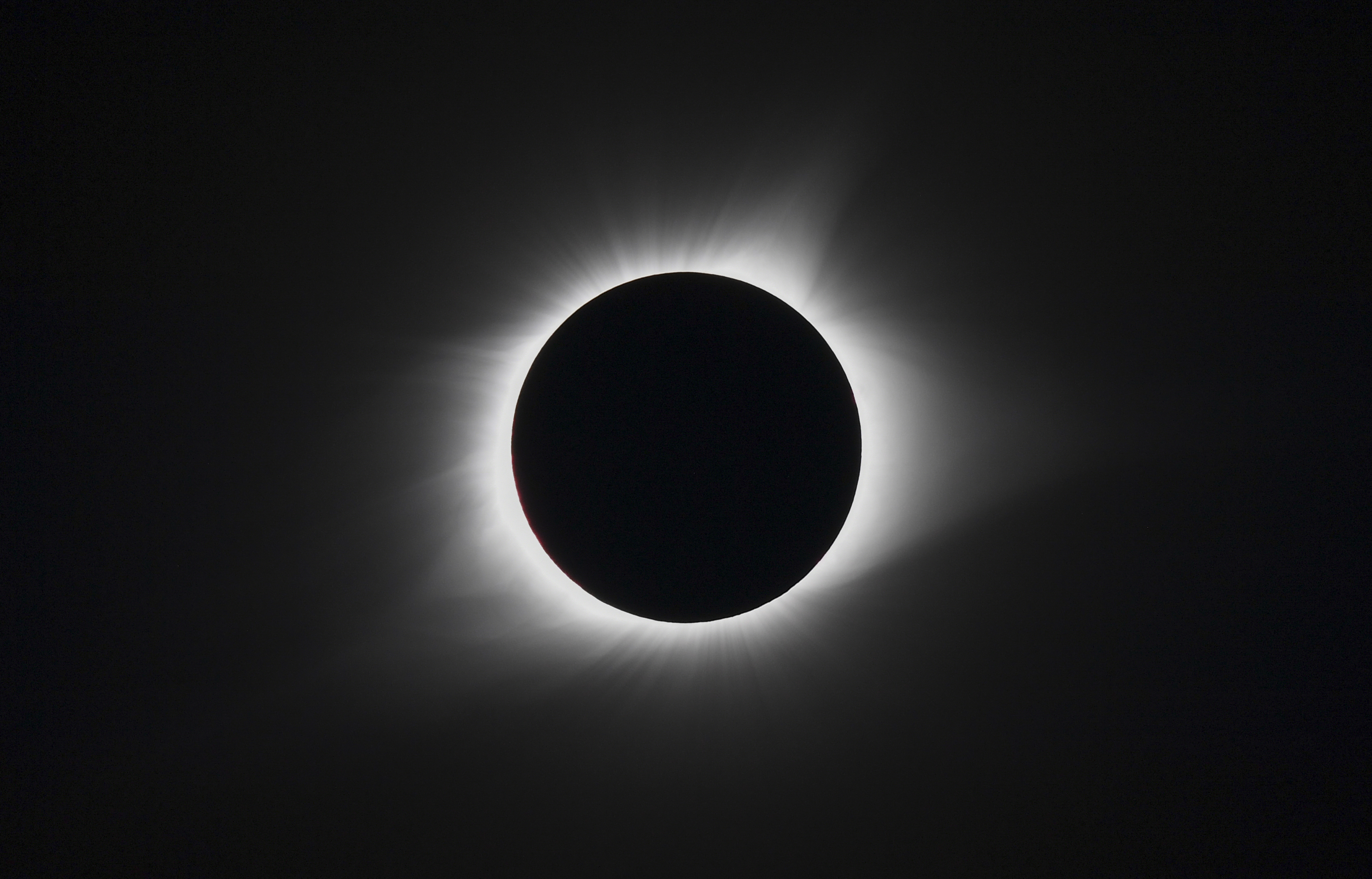 Solar eclipse with the moon blocking the sun&#x27;s center, creating a glowing halo