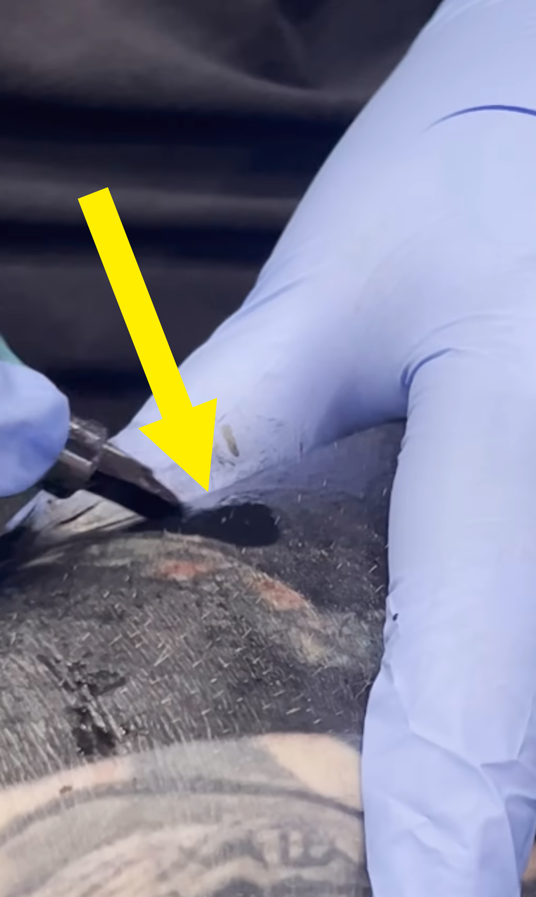 Close-up view of a gloved hand performing maintenance work, possibly welding, on a metal surface