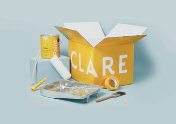 Paint can, tray, roller, and brush with open CLARE box, showcasing painting supplies for home improvement