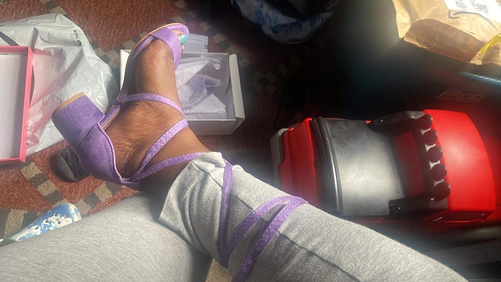Person wearing purple strap sandals with package materials around, indicating a recent unboxing or purchase
