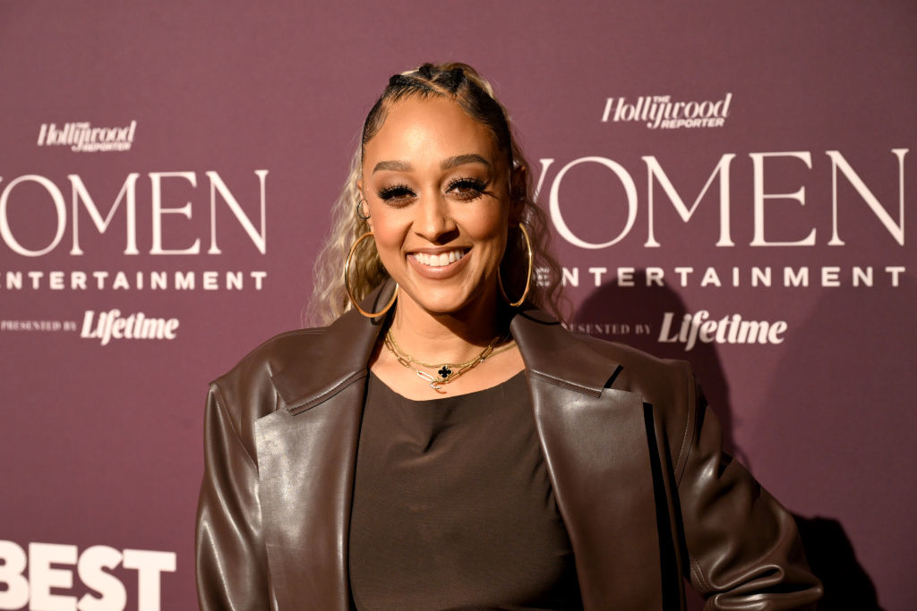 Tia smiling at a 'Hollywood Reporter Women in Entertainment' event, wearing a leather outfit
