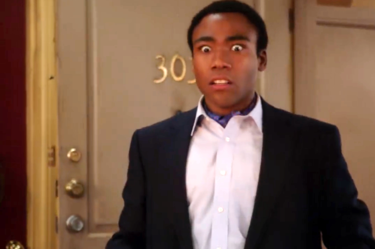 Surprised man in a doorway, wearing a suit sans tie, relevant to a travel-related topic