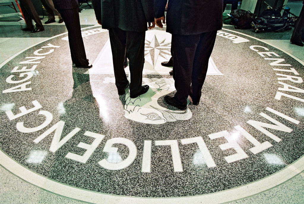 CIA emblem on floor with people&#x27;s lower halves visible around it