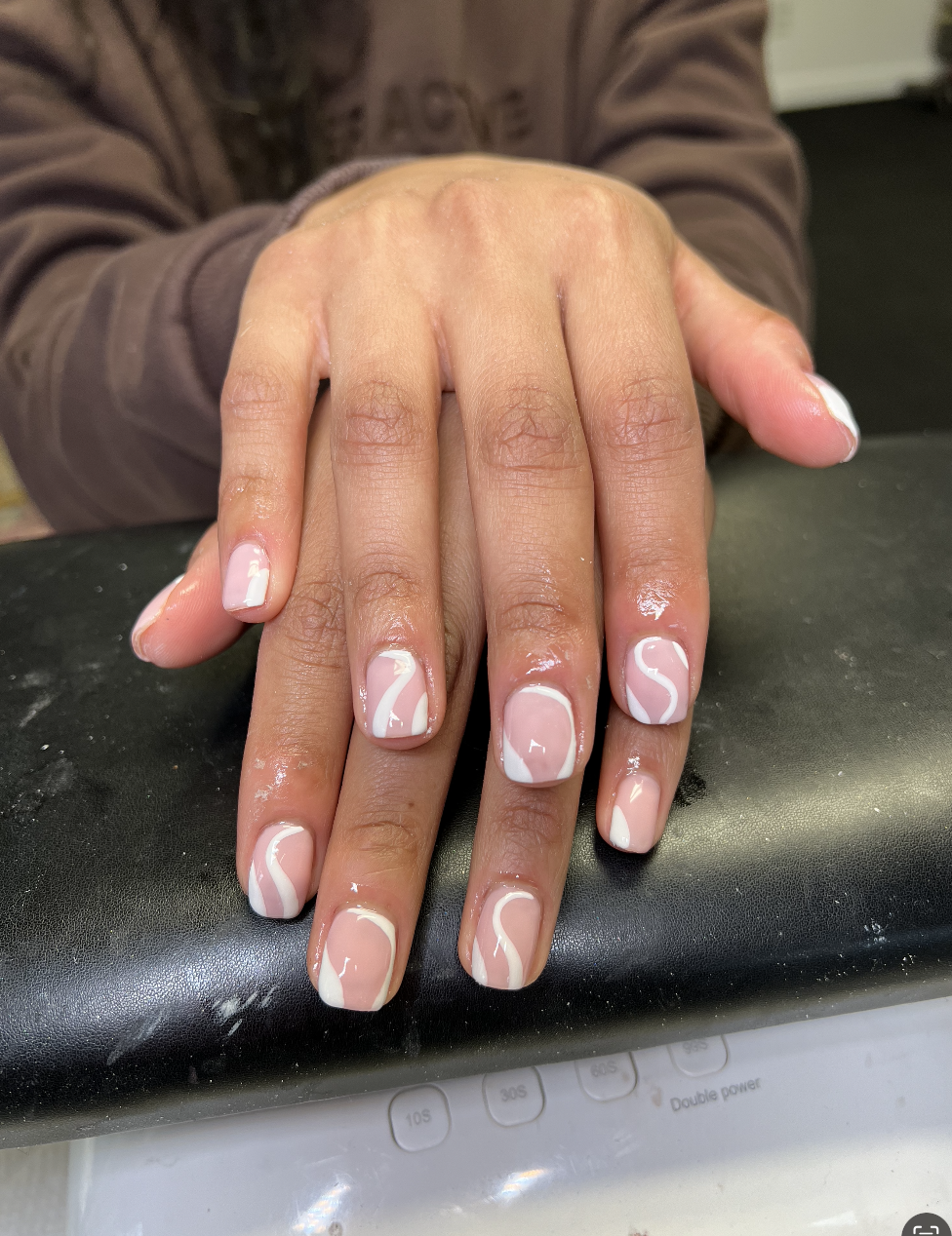 Hands with freshly done nails featuring a marble design