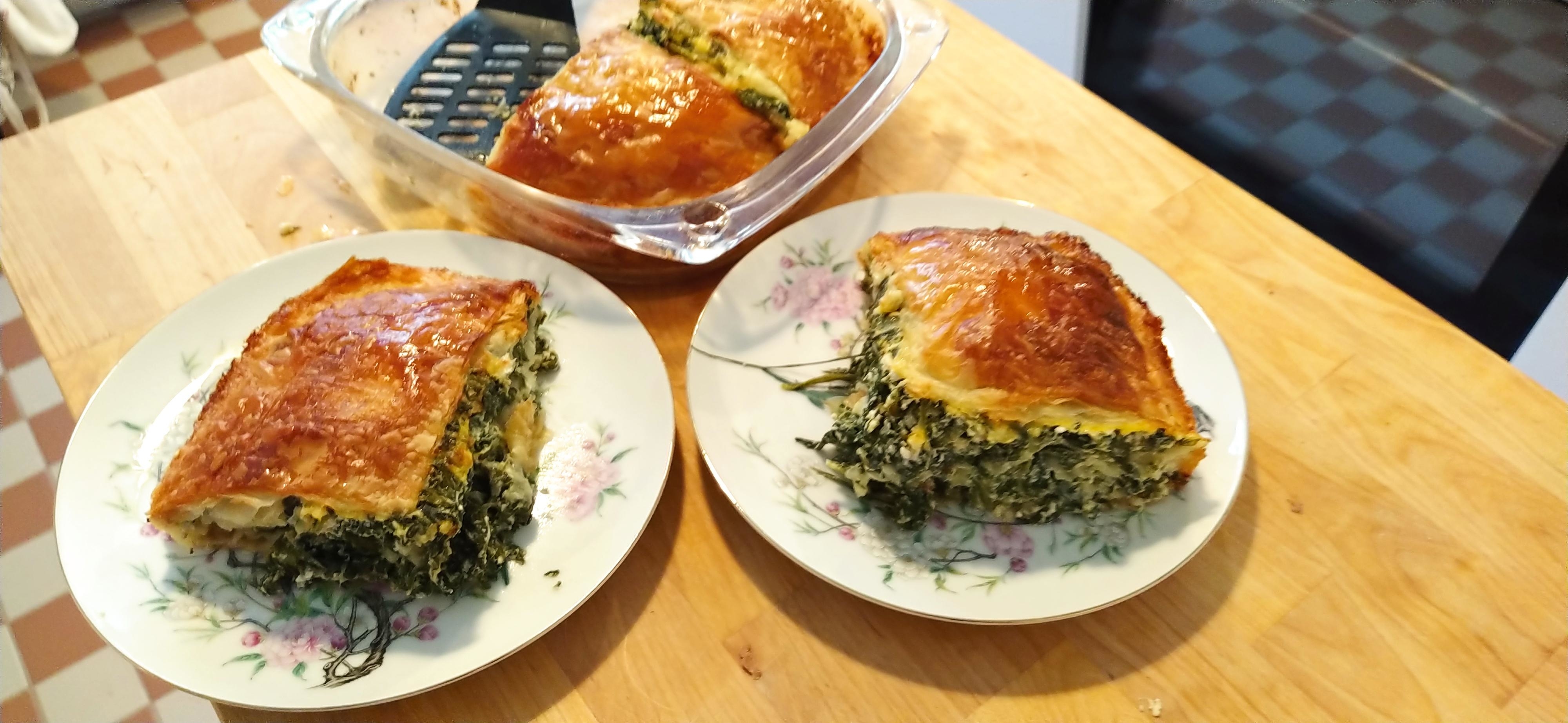 Two plates with slices of spinach pie on a kitchen counter