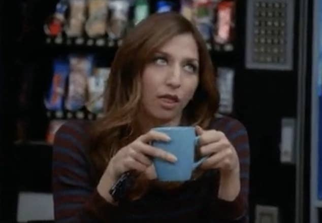 Woman in striped top holding a mug in office-like setting