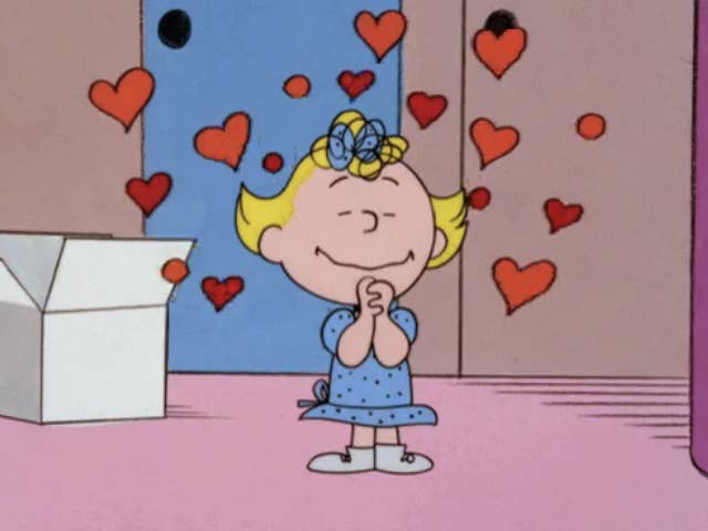 Sally from Peanuts cartoon daydreaming with hearts floating around her head