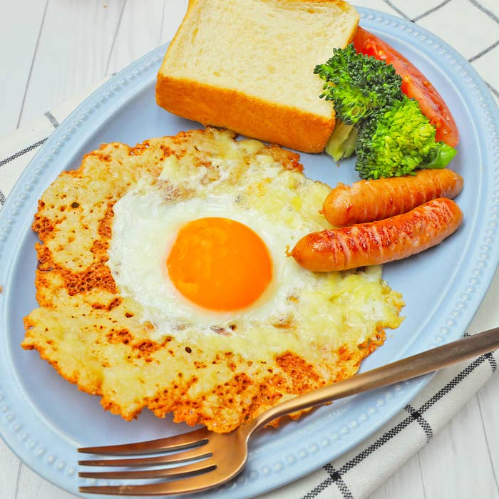 朝食用に準備された皿の上の目玉焼き、ソーセージ、トマト、ブロッコリー、トースト。