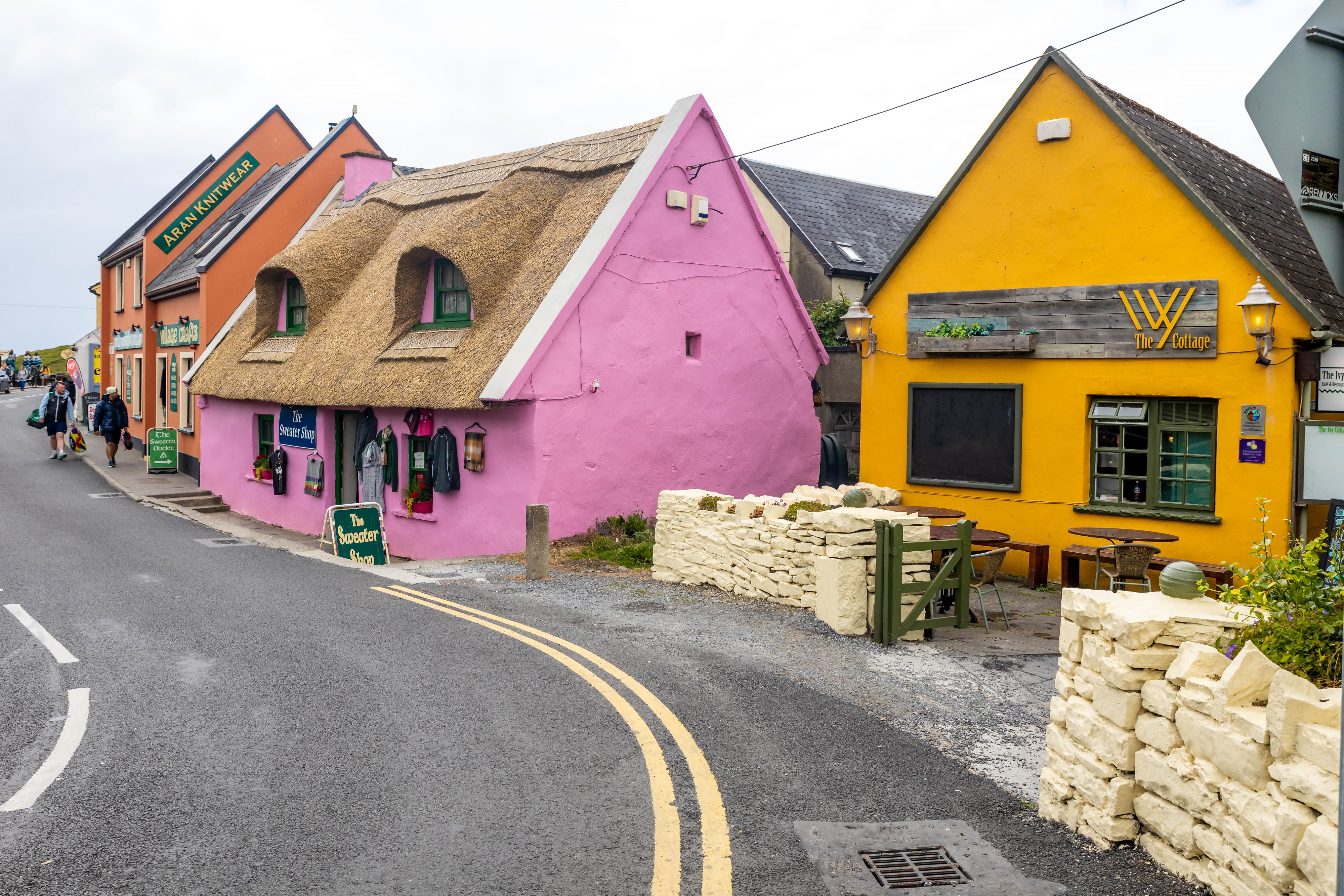 Quaint village street with traditional thatched cottage and bright colored buildings