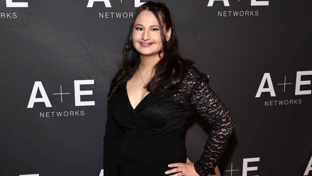 Woman in elegant black dress with lace sleeves posing at A+E Networks event
