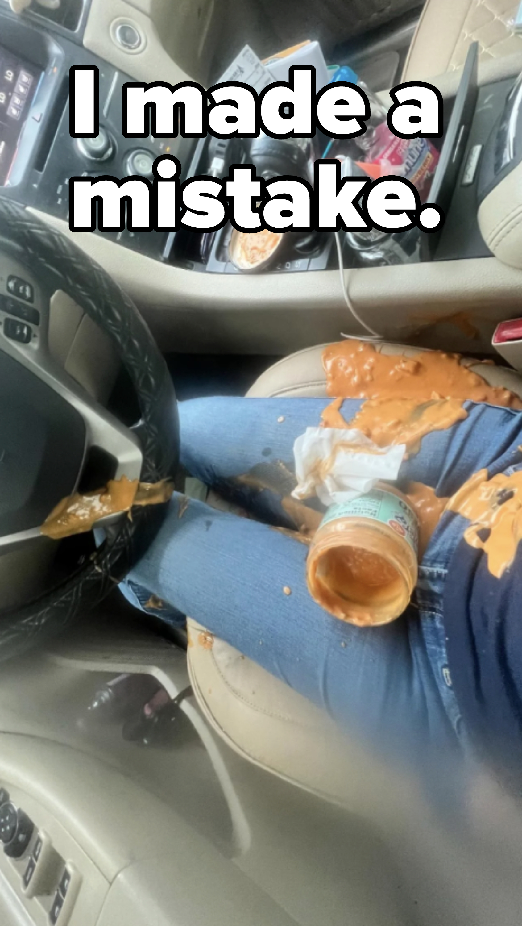 Person&#x27;s lap and car interior with spilled sauce and a jar.
