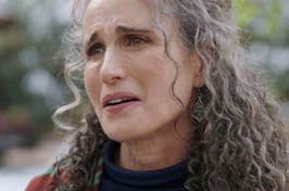 Close-up of an emotional woman with curly hair, expressing concern or sadness