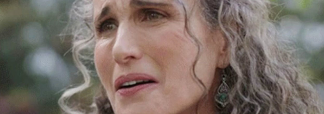 Close-up of an emotional woman with curly hair, expressing concern or sadness