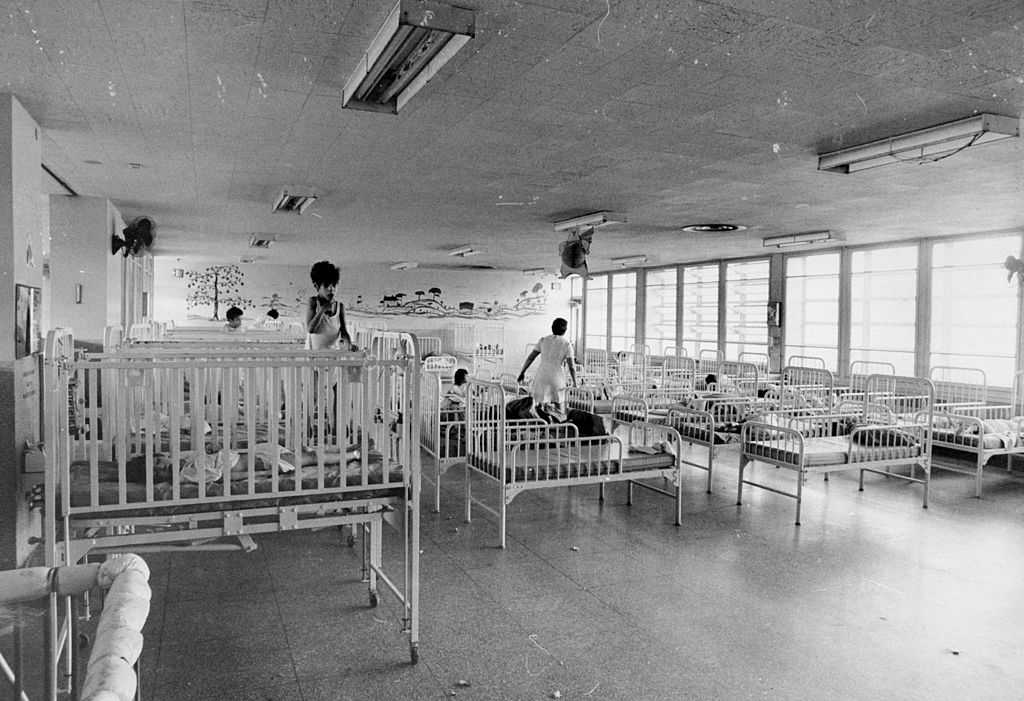 Nurses tending to cribs in a spacious hospital
