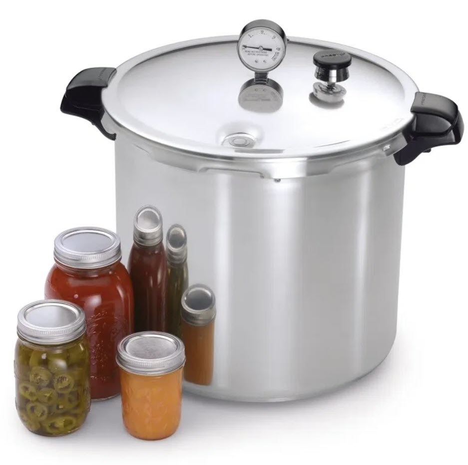 Pressure canner with gauge on top surrounded by assorted canned goods