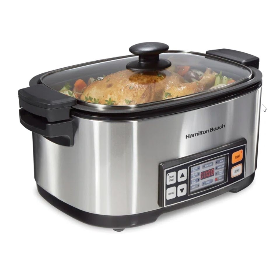 Stainless steel slow cooker full of food with lid on and digital display, branded Hamilton Beach