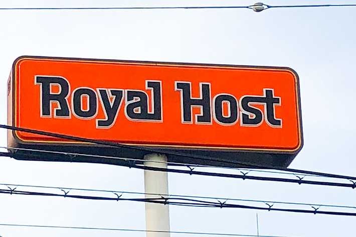 ロイヤルホストの看板が空に向かって掲げられている。
