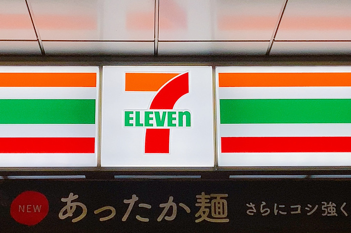 セブンイレブンの店舗看板、ロゴとストライプが特徴。