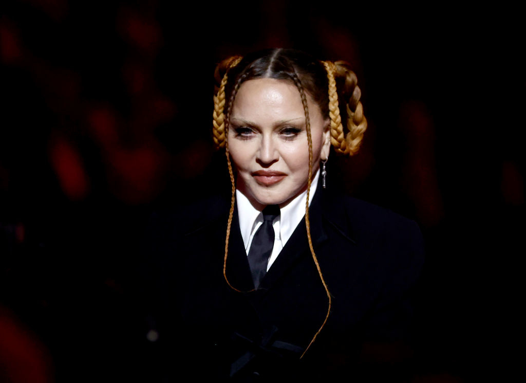 Person with braided hair and black outfit, standing at an event