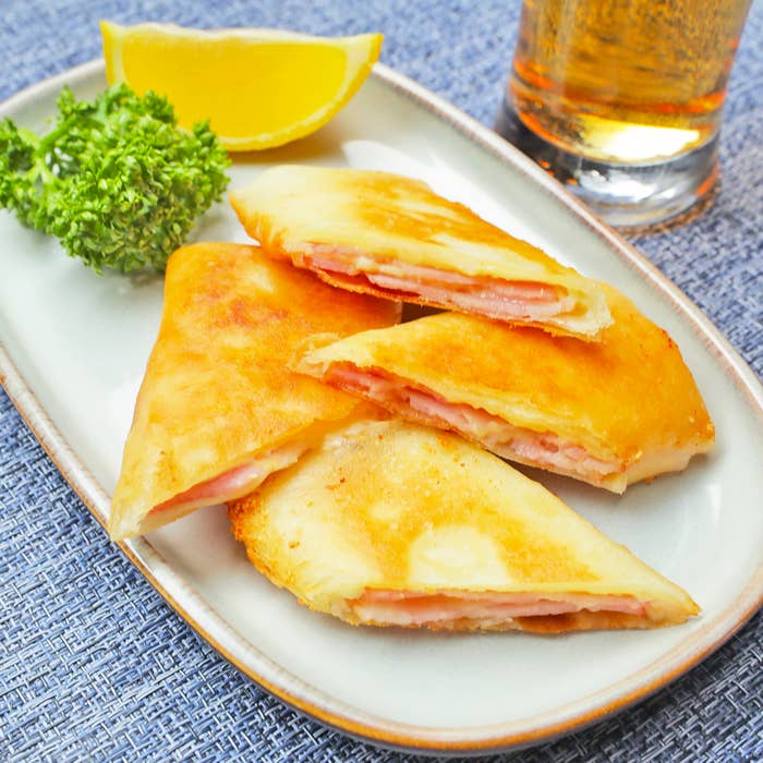 ベーコンとチーズが挟まった春巻きが皿に盛り付けられている。