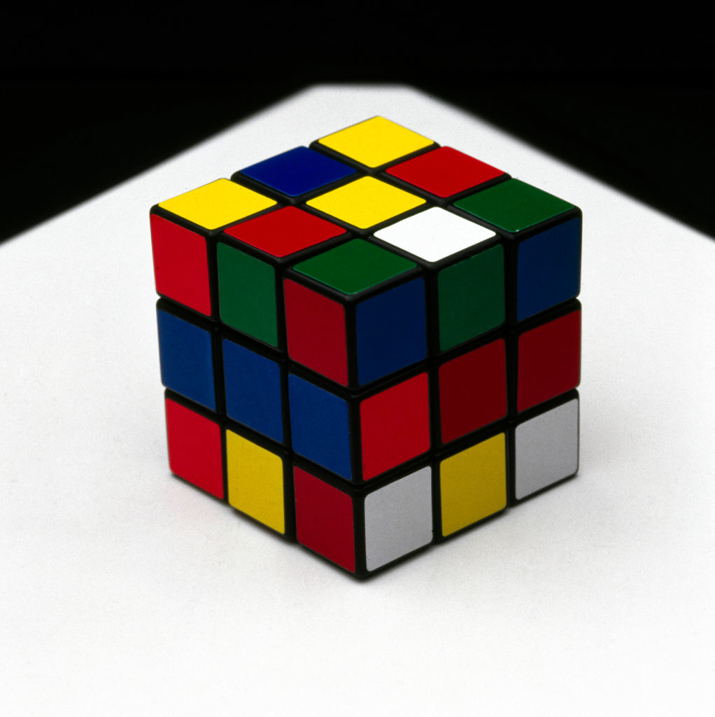 Rubik&#x27;s Cube partially solved on a reflective surface
