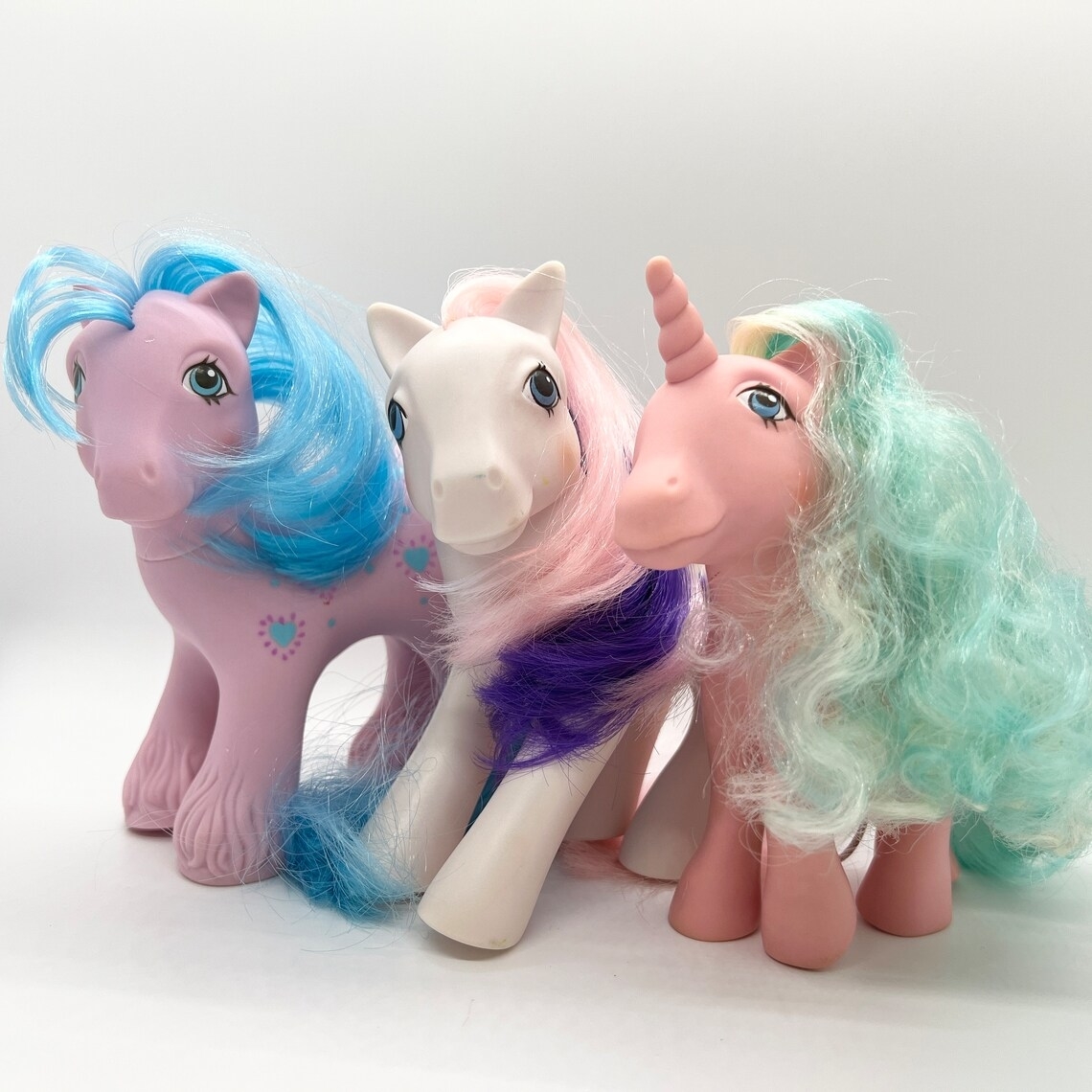 Three vintage My Little Pony figures standing together