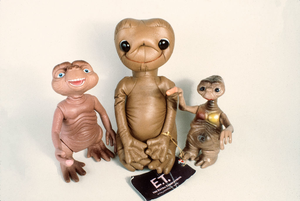 Three E.T. figurines from various sizes, with the largest in the center
