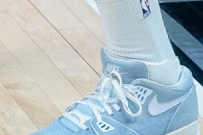 Close-up of a person's leg wearing a white NBA sock and a light blue Nike Air Jordan sneaker
