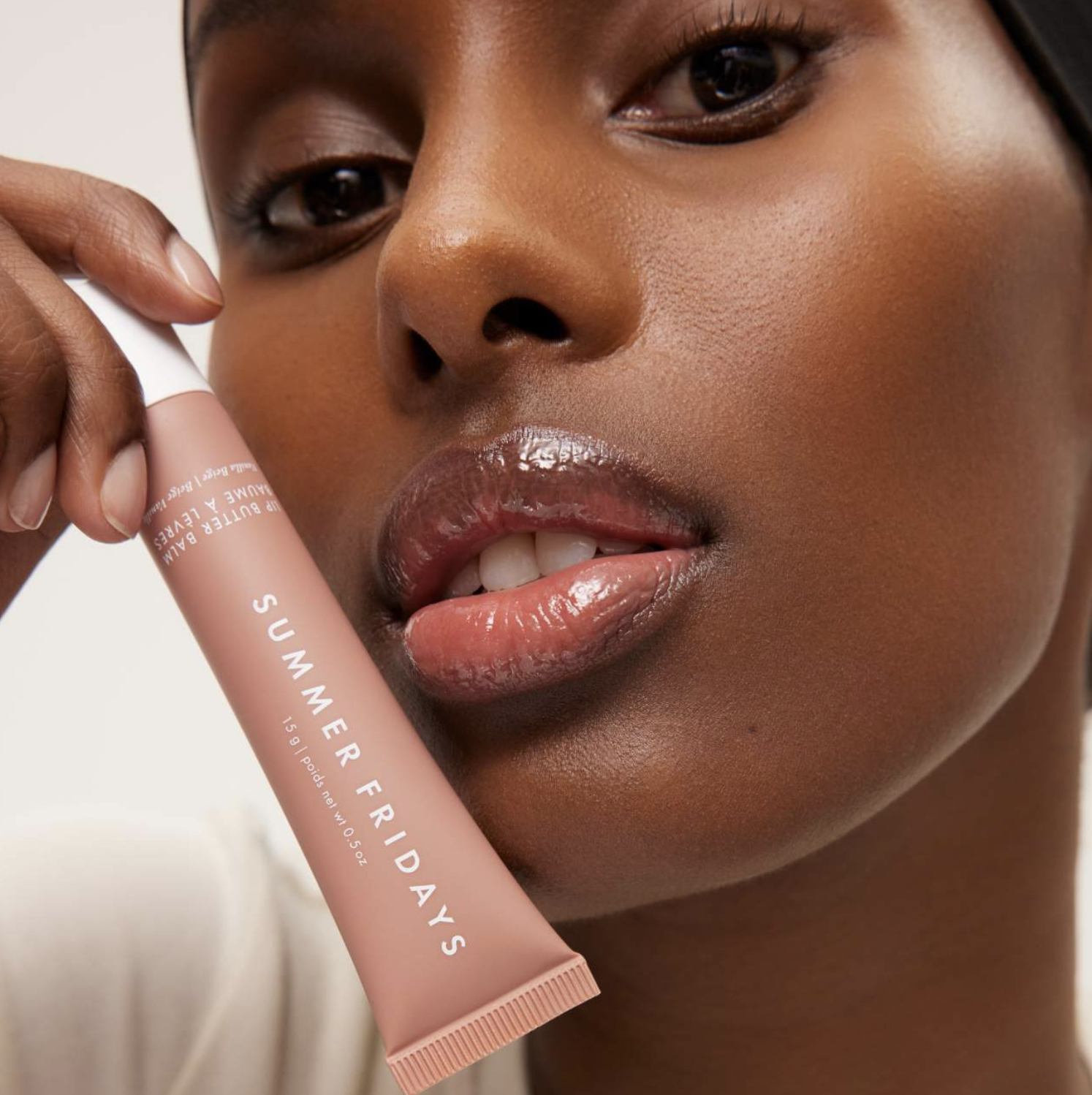 Close-up of a person holding a Summer Fridays skincare tube near their face