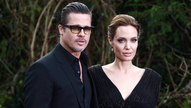 Brad Pitt and Angelina Jolie posing side by side, Brad in a black suit, Angelina in a sequined gown