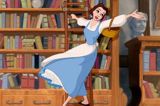 Belle from Beauty and the Beast in a library, arms open and a basket on her arm