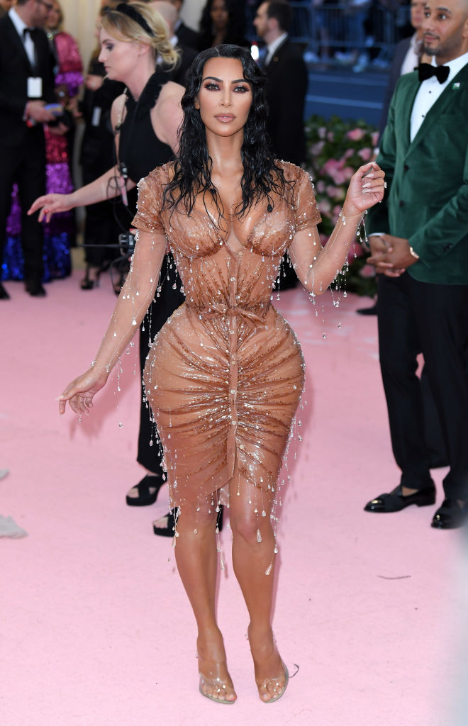 Kim Kardashian in a wet-effect, beaded nude dress and clear heels at an event