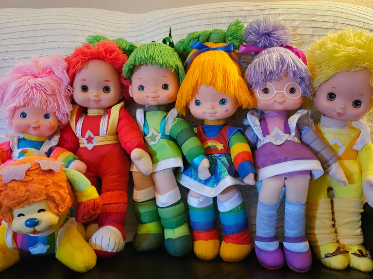 Collection of vintage Rainbow Brite character dolls with pet on display