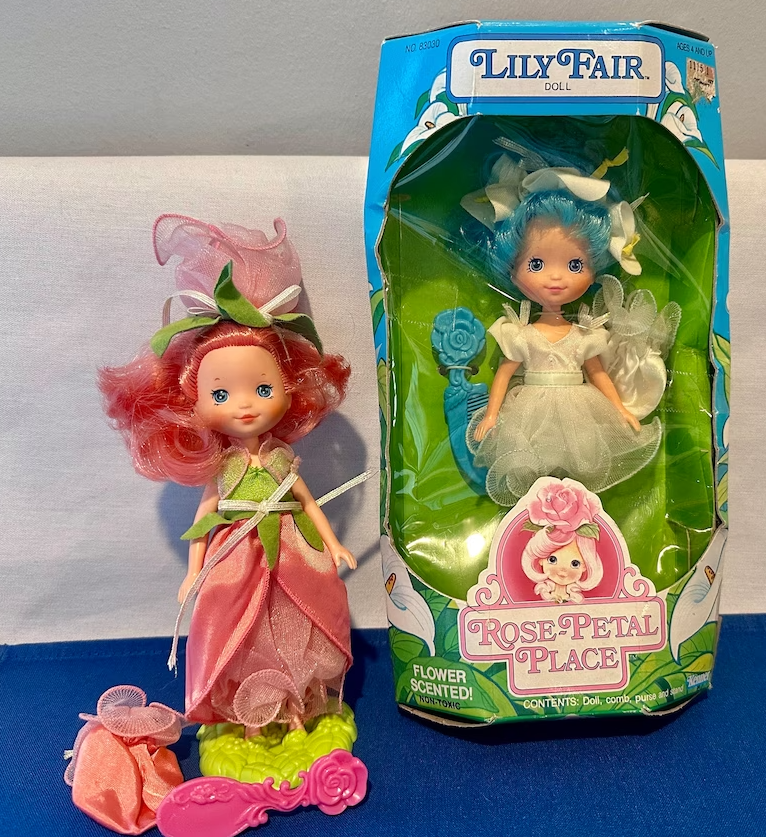 Two Lily Fair dolls from Rose Petal Place, one in box with blue attire, another out with pink dress and accessories