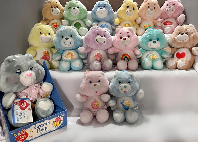 Collection of Care Bears plush toys arranged on steps